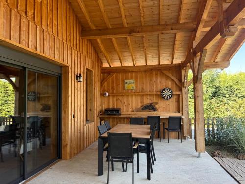 un patio in legno con tavolo e sedie di La cabane d' Esting a Mimizan