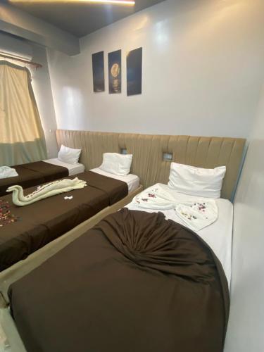 a small room with two beds in it at Pyramids Acme Inn in Nazlet el-Sîsi