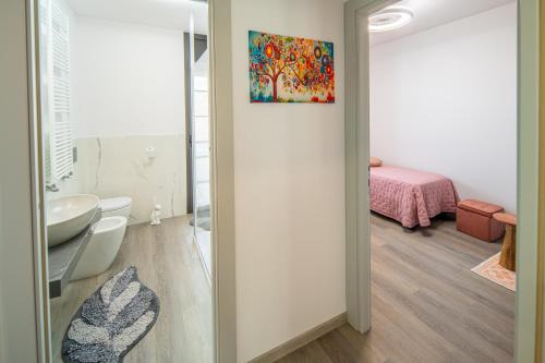 a bathroom with a toilet and a sink in a room at Locazione Turistica L'Aurora in Alba