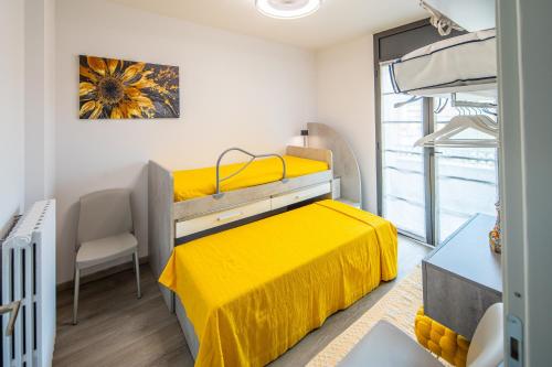 a bedroom with a bed with a yellow bedspread at Locazione Turistica L'Aurora in Alba