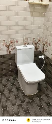 a bathroom with a white toilet in a room at S M LODGe in Dharmapuri