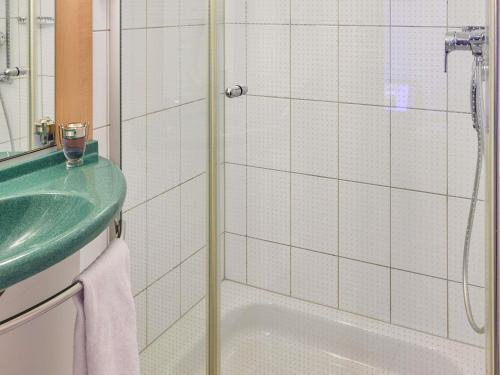 a bathroom with a green sink and a shower at ibis Baar Zug in Zug