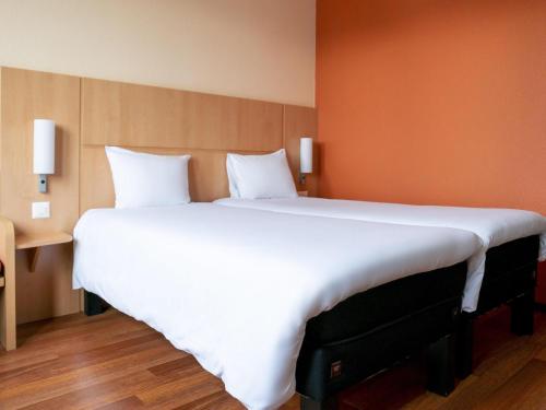 a large white bed in a hotel room at ibis Luzern Kriens in Luzern