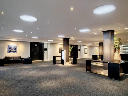a lobby with couches and tables in a building at Novotel Sao Paulo Center Norte in Sao Paulo