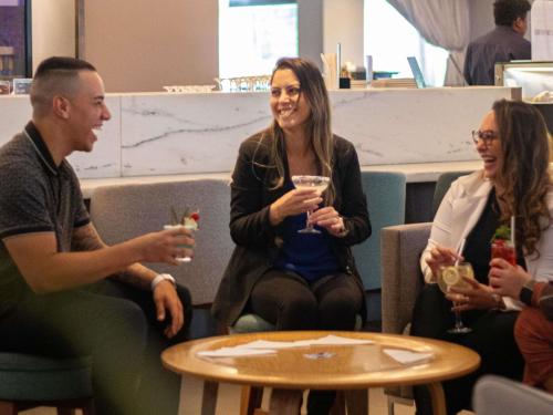a group of people sitting around a table with drinks at Novotel Sao Paulo Center Norte in Sao Paulo
