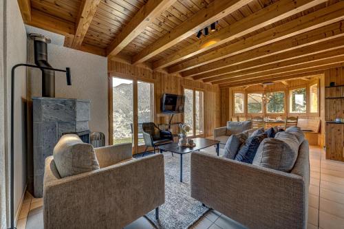 a living room with two couches and a fireplace at Chalet Colonia in La Tzoumaz