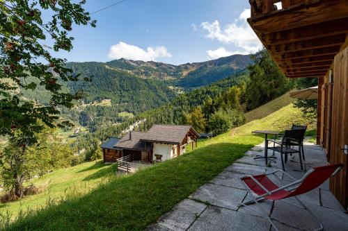 a patio with chairs and a table and a house at Chalet Colonia in La Tzoumaz