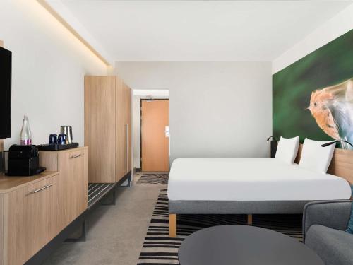 a hotel room with a bed and a couch at Novotel Szeged in Szeged