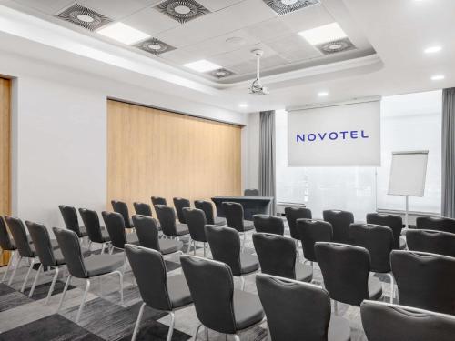 a conference room with chairs and a projection screen at Novotel Szeged in Szeged
