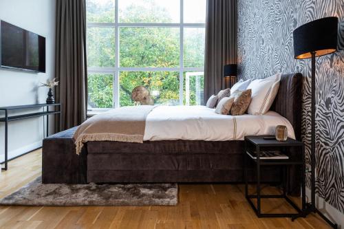a bedroom with a large bed and a large window at Suite With Bath City Center Villa Tilburg in Tilburg