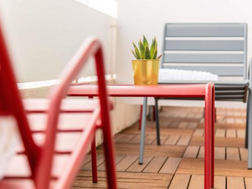a red table with a potted plant on it at Mercure Marseille Centre Prado Vélodrome in Marseille