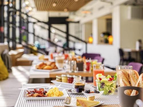 a table with plates of food on it at Mercure Marseille Centre Prado Vélodrome in Marseille