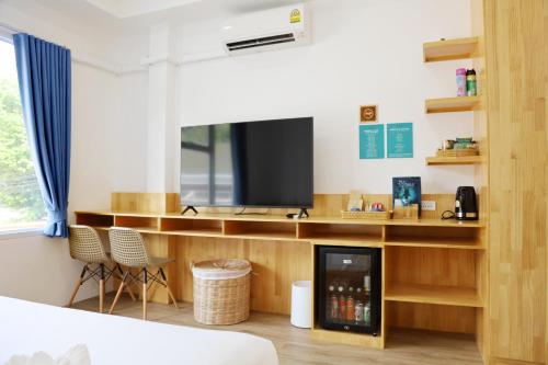 a room with a tv and a desk with a fireplace at Ibiza Beach Club Koh Tao in Koh Tao