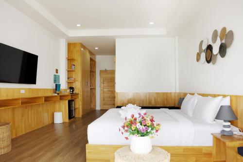 a bedroom with a white bed and a tv at Ibiza Beach Club Koh Tao in Koh Tao