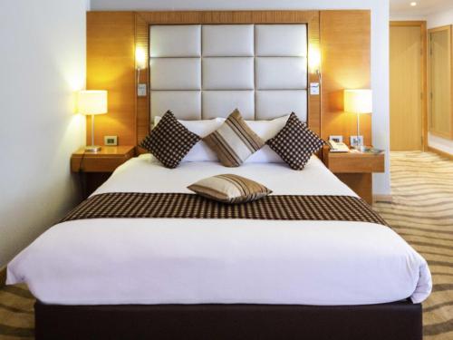 a bedroom with a large white bed with pillows at Mercure Ismailia Forsan Island in Ismailia