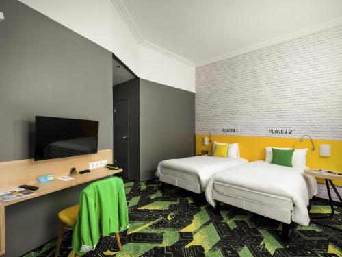a hotel room with two beds and a flat screen tv at Ibis Styles Budapest Center in Budapest