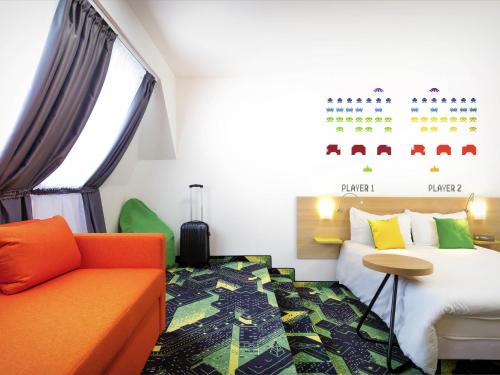 a hotel room with a bed and a couch at Ibis Styles Budapest Center in Budapest