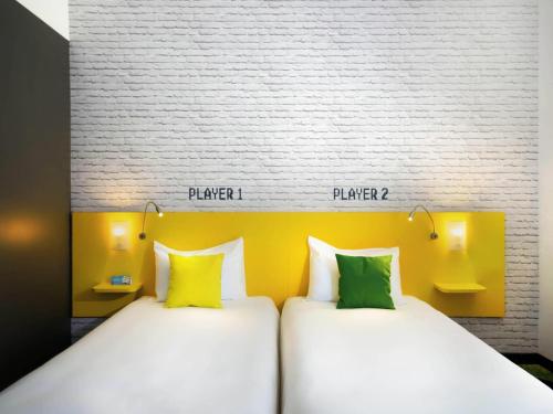 two beds sitting next to each other in a room at Ibis Styles Budapest Center in Budapest