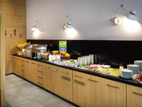 a buffet line in a restaurant with food at Ibis Styles Budapest Center in Budapest