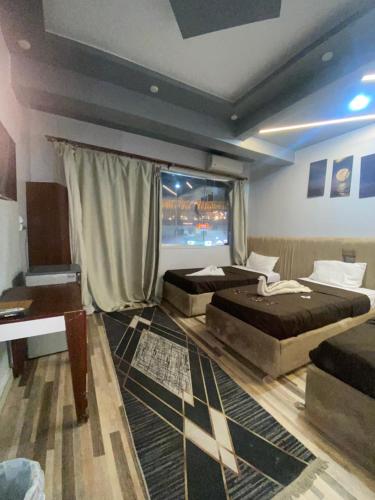 a bedroom with two beds and a window at Pyramids Acme Inn in Nazlet el-Sîsi