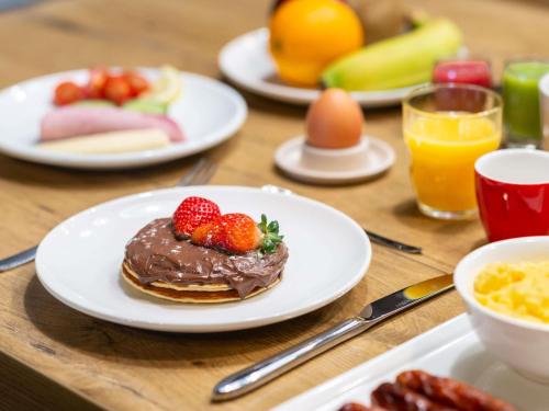 a table topped with plates of pancakes and strawberries at ibis Strasbourg Centre Gare in Strasbourg