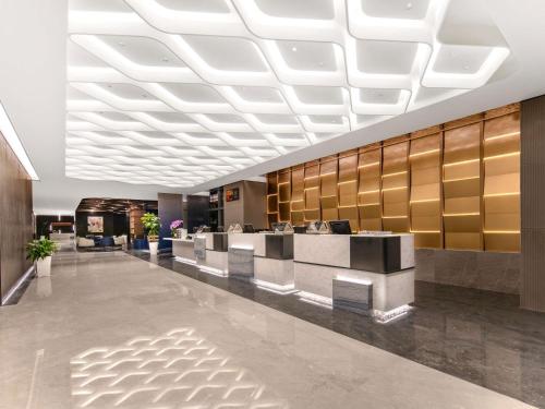 a lobby of a hotel with a reception desk at Novotel Atlantis Shanghai - Enjoy our great-valued breakfast in our rooftop revolving restaurant with a stunning river view & utilize our FREE self-serviced laundry in Shanghai