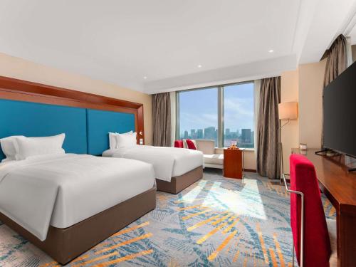 Letto o letti in una camera di Novotel Atlantis Shanghai - Enjoy our great-valued breakfast in our rooftop revolving restaurant with a stunning river view & utilize our FREE self-serviced laundry