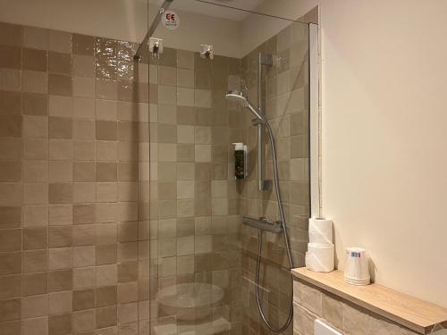 a shower with a glass door in a bathroom at Adonis Sanary Grand Hôtel des Bains in Sanary-sur-Mer