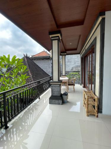 a balcony with a fireplace and a table and chairs at Suntari Homestay in Ubud