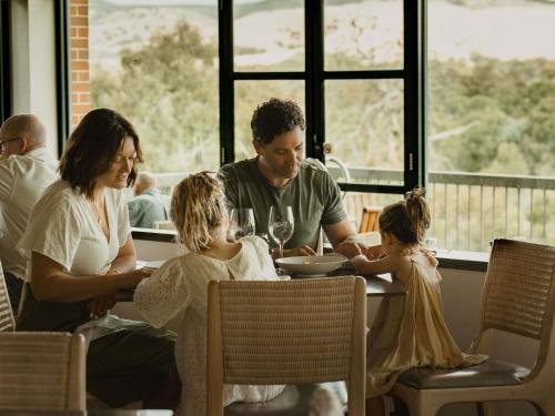 une famille assise à une table dans un restaurant dans l'établissement Novotel Barossa Valley Resort, à Rowland Flat