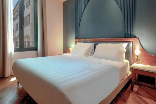 Ένα ή περισσότερα κρεβάτια σε δωμάτιο στο B&B Hotel Firenze Laurus Al Duomo