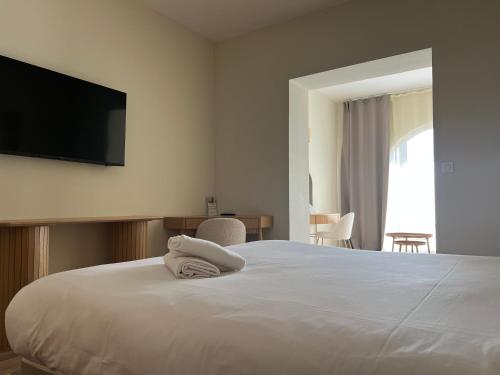 a bedroom with a bed with a flat screen tv on the wall at Adonis Sanary Grand Hôtel des Bains in Sanary-sur-Mer
