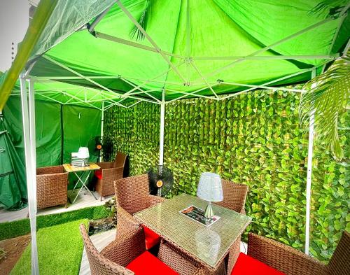 a green wall with a table and chairs in a tent at Vintage Classic Hotel in Lagos