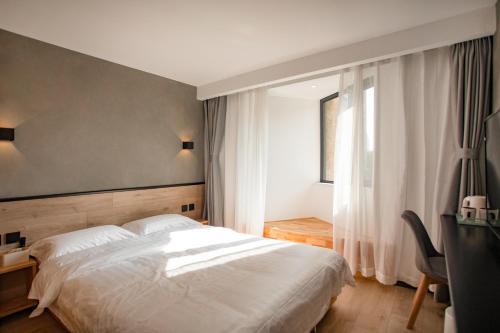 a bedroom with a large white bed and a window at Xinxian inn Beijing Railway Station in Beijing