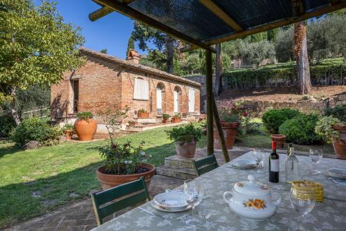 a table with a plate of food on it in a garden at Maria Gabriella Holiday Home In Monticchiello in Monticchiello