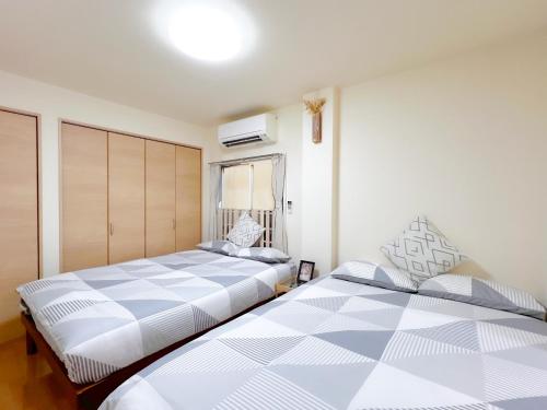 two beds sitting next to each other in a bedroom at Asakusa 2DB Stuido Free Wi-Fi in Tokyo