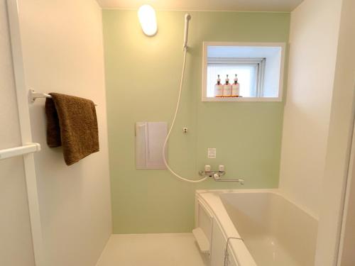 a bathroom with a bath tub and a window at Asakusa 2DB Stuido Free Wi-Fi in Tokyo