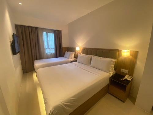 吉隆坡D Loft Hotel的有两张床和一台电视的酒店房间