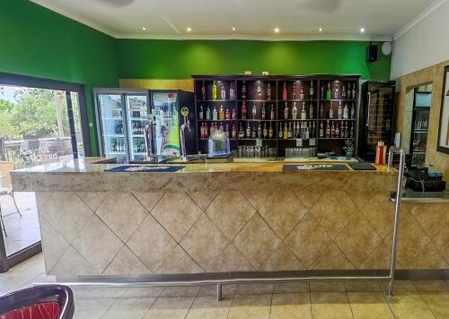 a bar in a restaurant with a green wall at Piekenierskloof Mountain Resort by Dream Resorts in Citrusdal