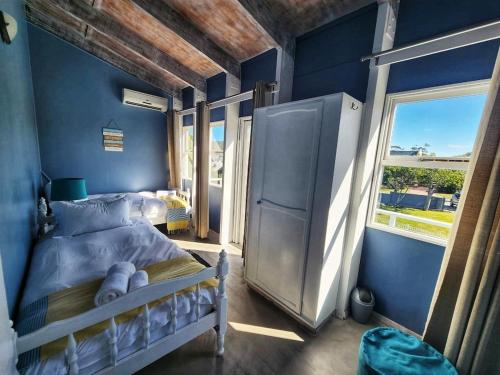 a blue bedroom with a bed and a window at Sedgefield Holiday Accommodation in Sedgefield