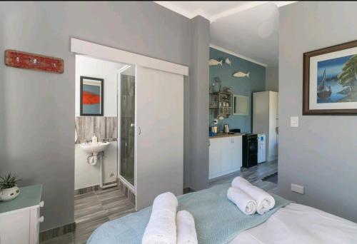 a bedroom with a sink and a bed with towels at Sedgefield Holiday Accommodation in Sedgefield