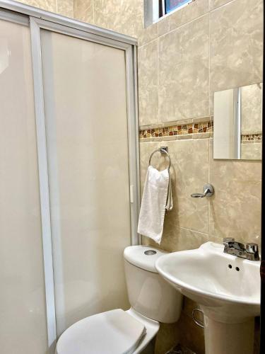 a bathroom with a shower and a toilet and a sink at Family Size - 4BR House in Oaxaca - Peaceful in Oaxaca City