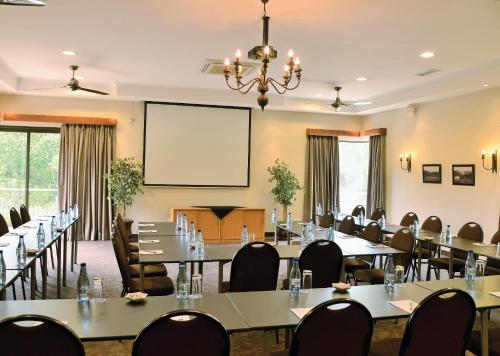 a conference room with tables and chairs and a projection screen at Piekenierskloof Mountain Resort by Dream Resorts in Citrusdal