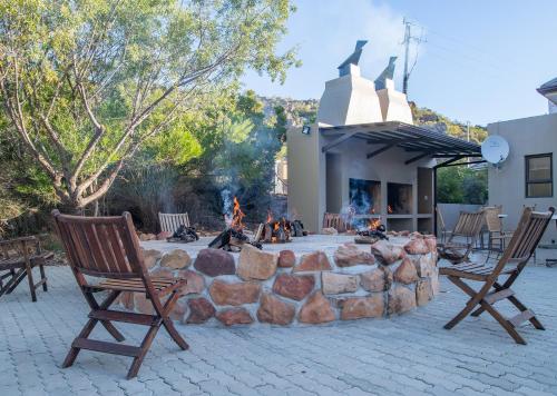 a fire pit in a patio with two rocking chairs at Piekenierskloof Mountain Resort by Dream Resorts in Citrusdal