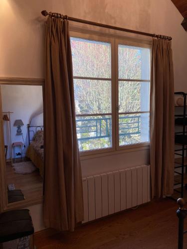 a bedroom with a large window and a bed at Chalet Loft pour escapades en bords de Loire in Monteaux