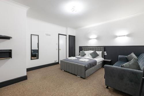 a bedroom with a bed and a couch at Magic Stay Rooms in London