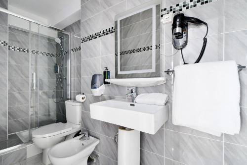 a white bathroom with a sink and a toilet at Altona in Paris