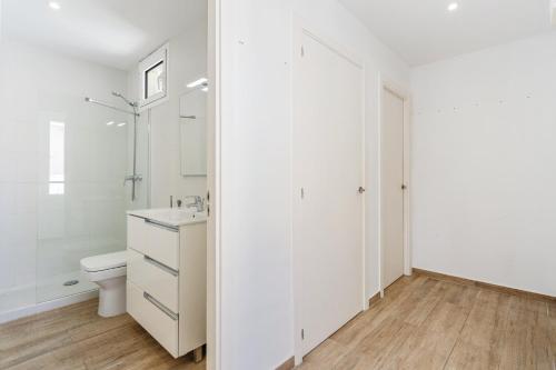 a white bathroom with a toilet and a sink at AB Poble Sec - Plaza España in Barcelona