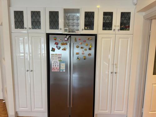 a refrigerator in a kitchen with white cabinets at Geelong Chang House in Bell Post Hill