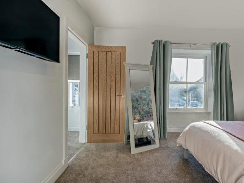 Un dormitorio con una cama, un espejo y un televisor. en 2 Bed in Kelso 95838, en Kelso